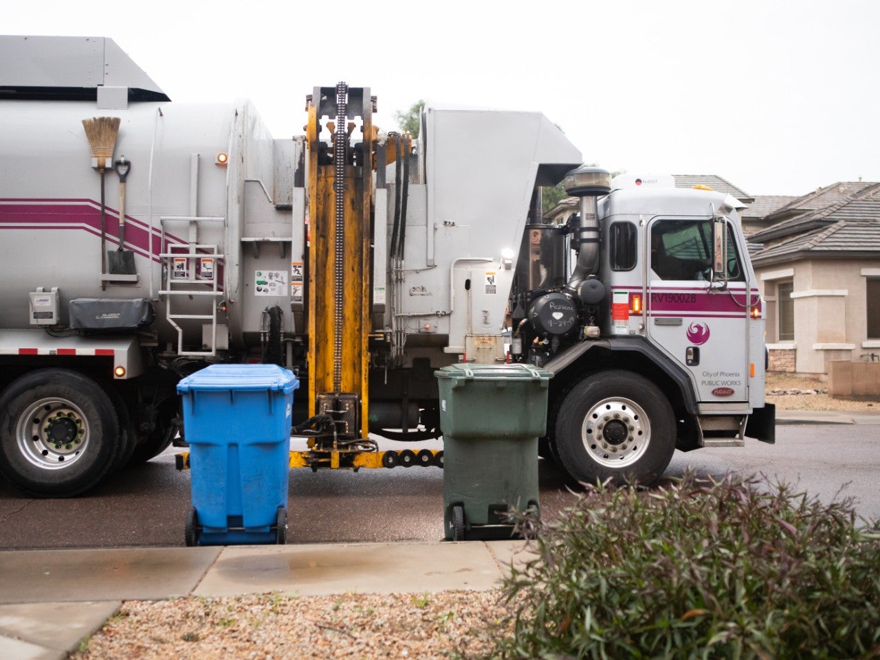 Recycle truck collects recycling at a household.